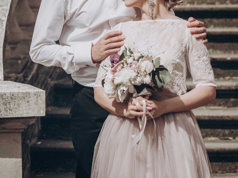 stylish wedding couple with bouquet